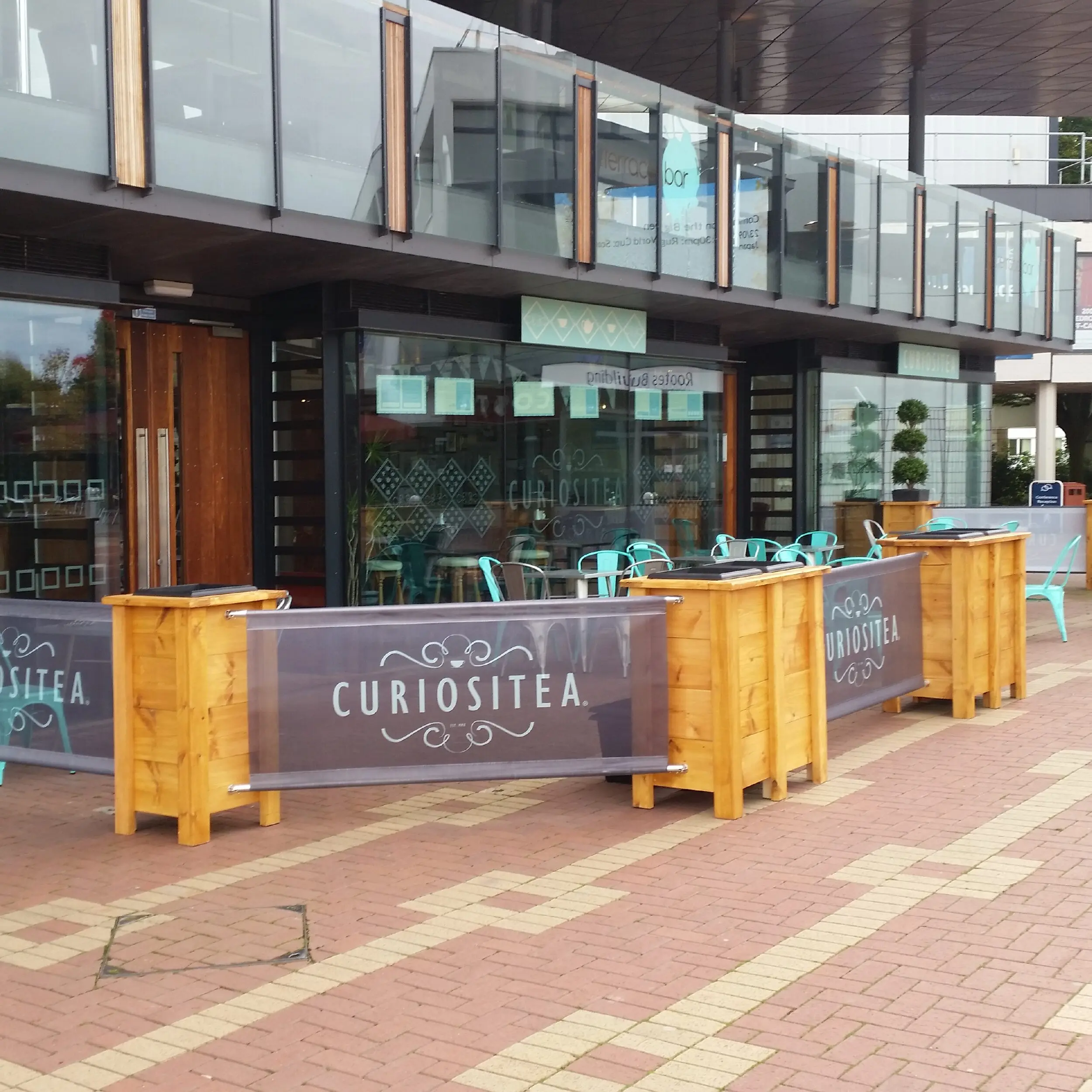 Curiositea, Warwick Uni- Vigo Wooden Cafe Planter Restaurant Vigo Wooden Cafe Planter matched with our PVC Mesh Cafe Banners. Pavement Barriers & Heavy Duty Cafe Barriers for Use Outdoors.