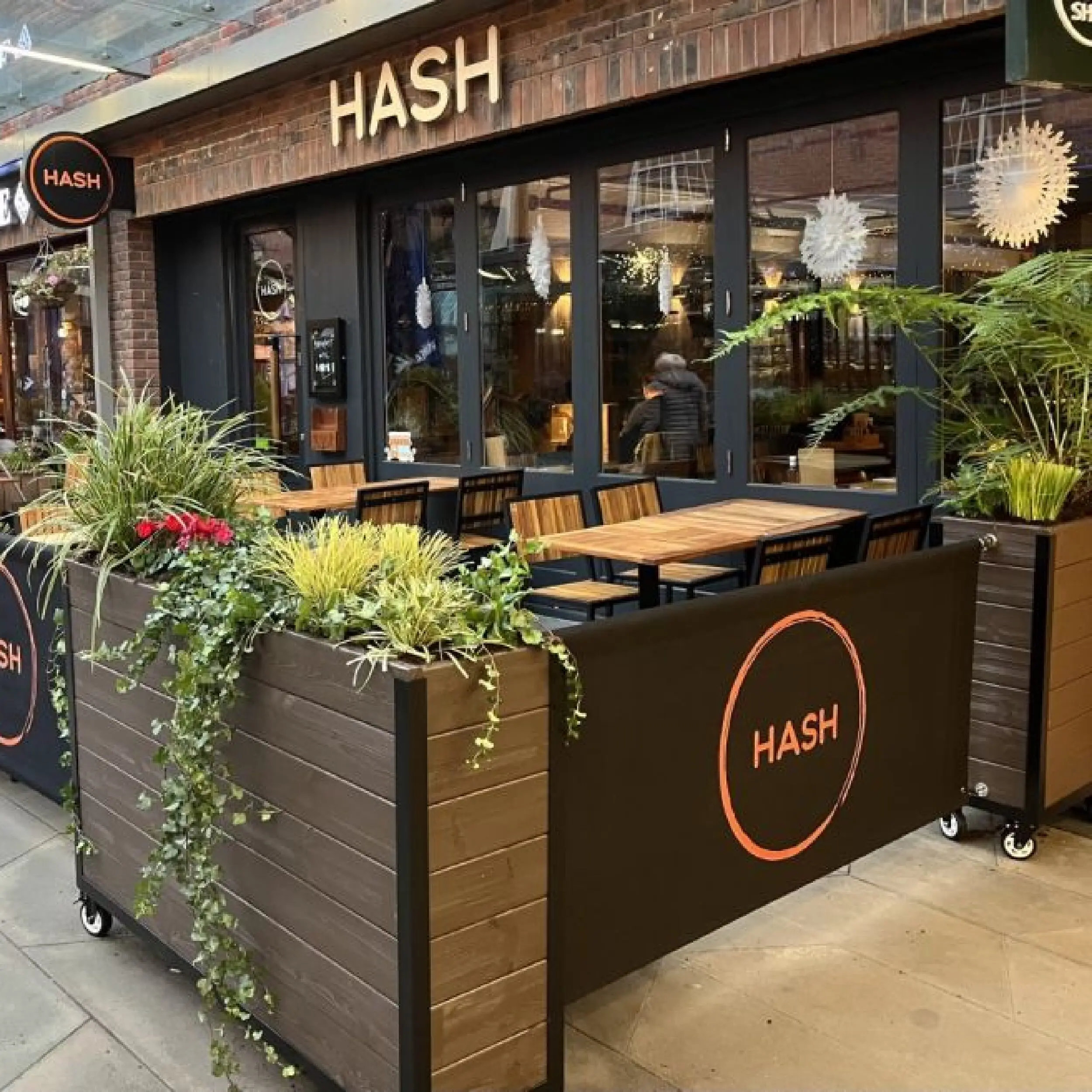 Hash Restaurant - Baylis Industrial Cafe Planter Hash Restaurant with our Wooden Baylis Industrial Cafe Planters and Canvas Café Banners in Brown, printed café banners, bespoke café banners, handmade café banners, custom café banners, café screens, fabric café banners, bespoke planters, custom made cafe planters, heavy duty cafe barriers, branded cafe barriers, pavement barriers, wooden planters, commercial cafe planters, cafe barrier system, outdoor cafe barriers