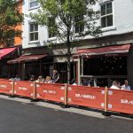 Bar Iberico Rustic Cafe Barrier Posts with Red Canvas Banners and Their Logo