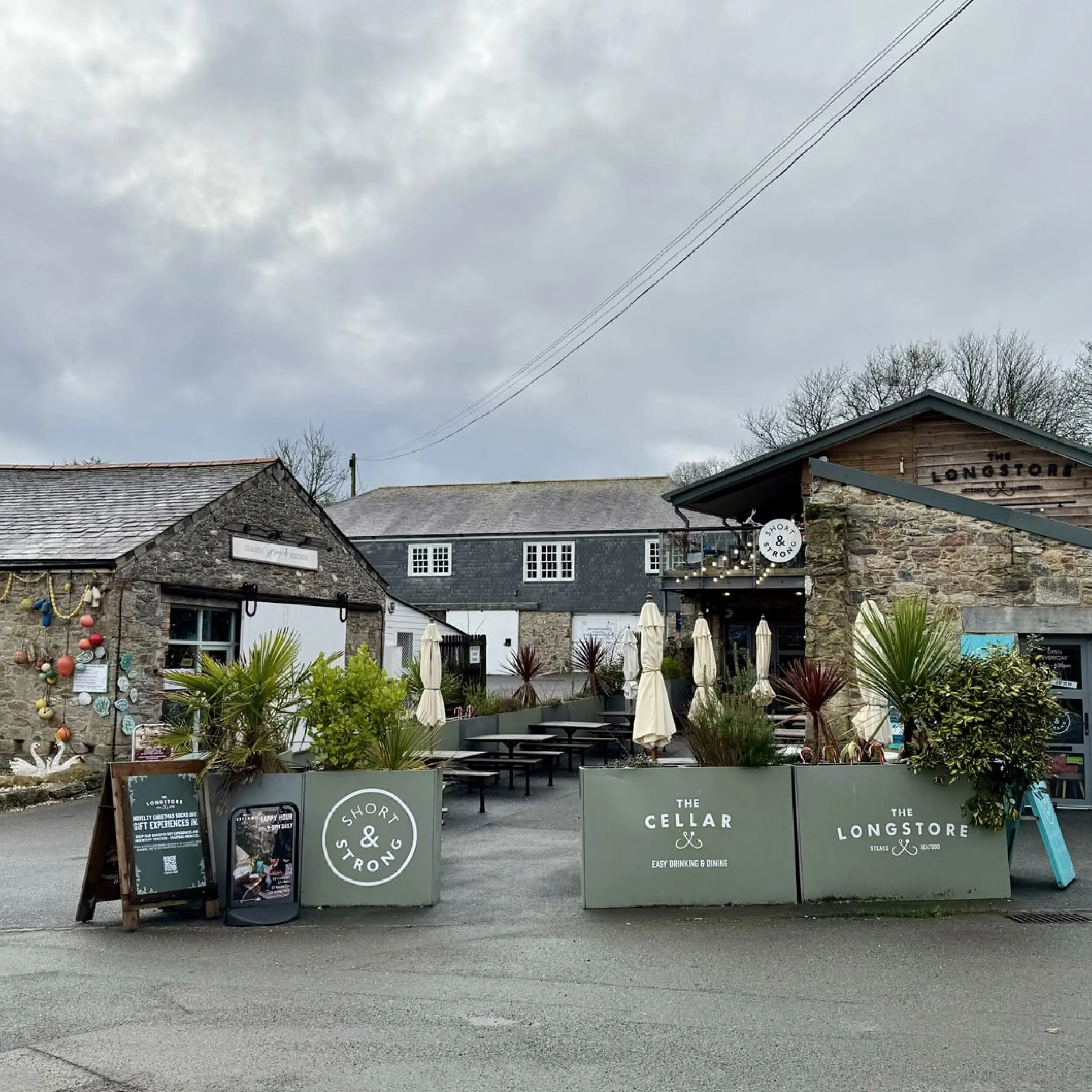 The Longstore 1 - Forjado Powder Coated Café Planter Longshore Restaurant in Cornwall Forjado Metal Planters Powder Coated in Green with their logos to all, Commercial Planters, Heavy Duty Cafe Planters, Metal Planters, Bespoke Cafe Planters, Branded Cafe Planters, Custom Cafe Planters, Outdoor Cafe Planters, Pavement Planters