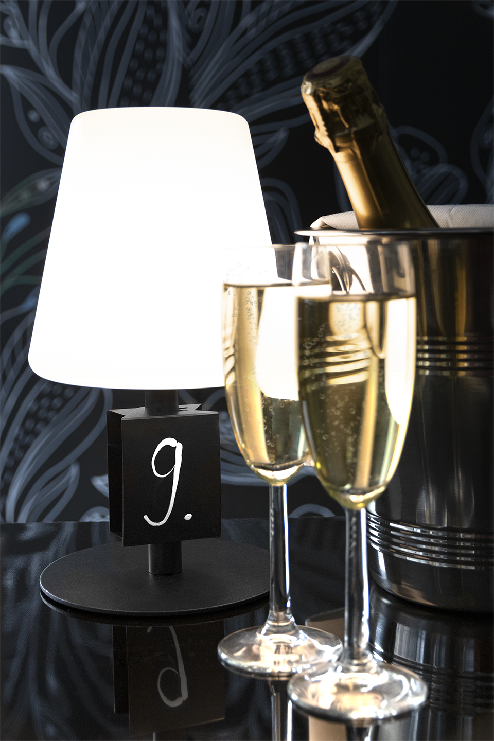 Michel Rechargeable Table Lamp in Black with Mini Chalkboard next to Champagne and Glasses Michel Rechargeable Table Lamp in Black with Mini Chalkboard next to Champagne and Glasses, Table Lighting, Restaurant Lighting, Lighting for Table at Restaurant, Commercial Table Lighting, Hospitality Lighting, Rechargeable Table Lamps, LED Lighting, Outdoor Table Lamps, Indoor Table Lighting, Cafe Lighting, Table Lamps for Cafes, Vase Table Lamp, Table Lamp for Flowers