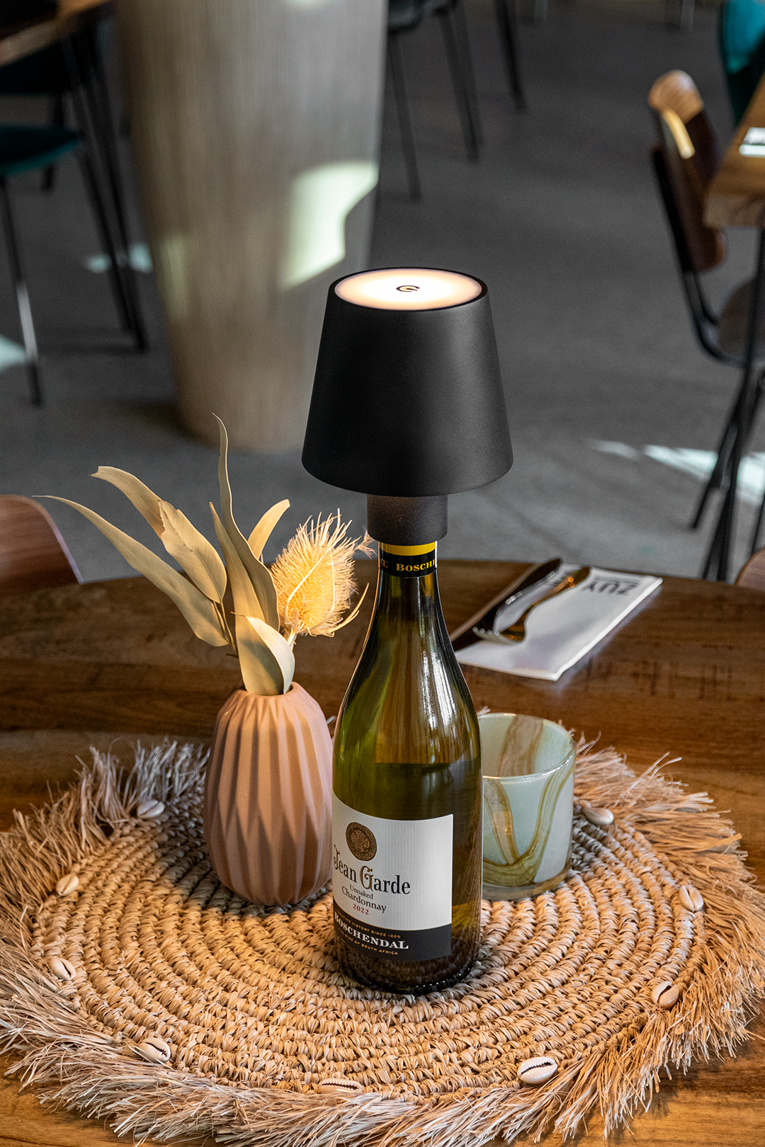 Versailles Rechargeable Bottle Lamp on a Wooden Table Inside a Restaurant Versailles Rechargeable Bottle Lamp in Black on a Wooden Table Inside a Restaurant, Table Lighting, Restaurant Lighting, Lighting for Table at Restaurant, Commercial Table Lighting, Hospitality Lighting, Rechargeable Bottle Lamps, LED Lighting, Outdoor Bottle Lamps, Indoor Table Lighting, Cafe Lighting, Bottle Lamps for Cafes