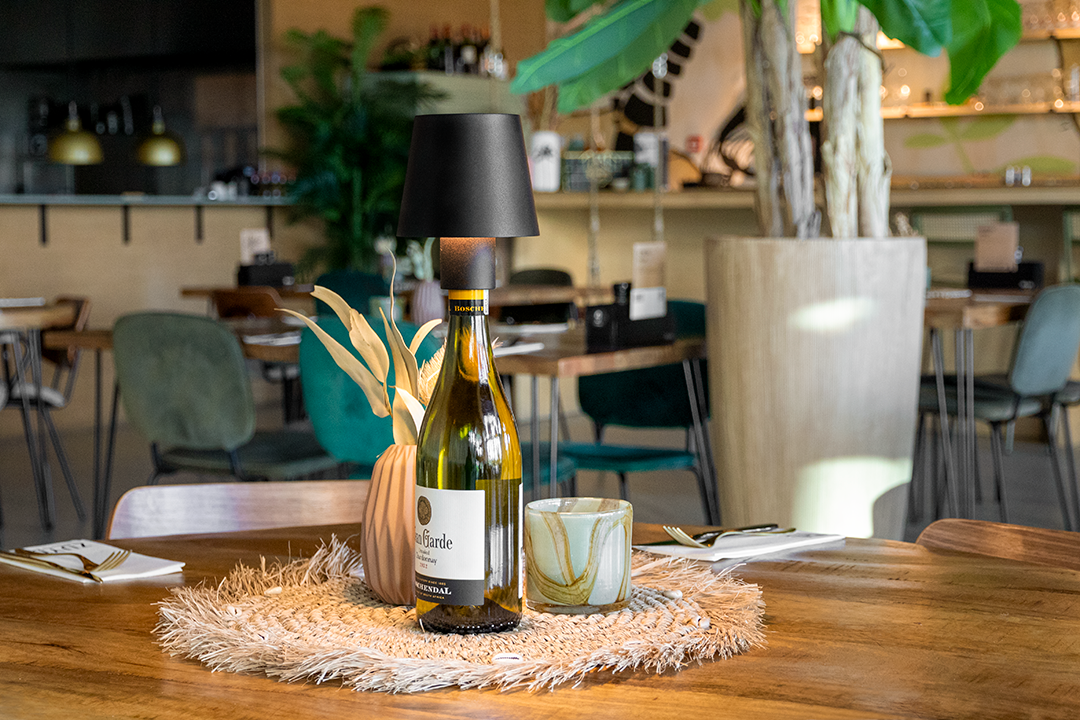 Versailles Rechargeable Bottle Lamp on a Wooden Table Inside a Restaurant Versailles Rechargeable Bottle Lamp in Black on a Wooden Table Inside a Restaurant, Table Lighting, Restaurant Lighting, Lighting for Table at Restaurant, Commercial Table Lighting, Hospitality Lighting, Rechargeable Bottle Lamps, LED Lighting, Outdoor Bottle Lamps, Indoor Table Lighting, Cafe Lighting, Bottle Lamps for Cafes