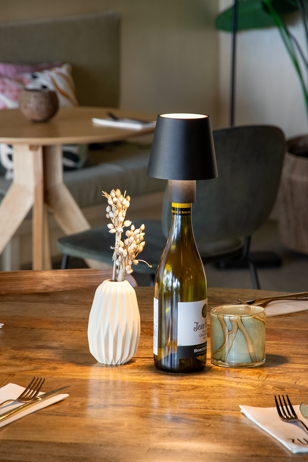Versailles Rechargeable Bottle Lamp on a Wooden Table Inside a Restaurant Lit Up Versailles Rechargeable Bottle Lamp in Black on a Wooden Table Inside a Restaurant Lit Up, Table Lighting, Restaurant Lighting, Lighting for Table at Restaurant, Commercial Table Lighting, Hospitality Lighting, Rechargeable Bottle Lamps, LED Lighting, Outdoor Bottle Lamps, Indoor Table Lighting, Cafe Lighting, Bottle Lamps for Cafes