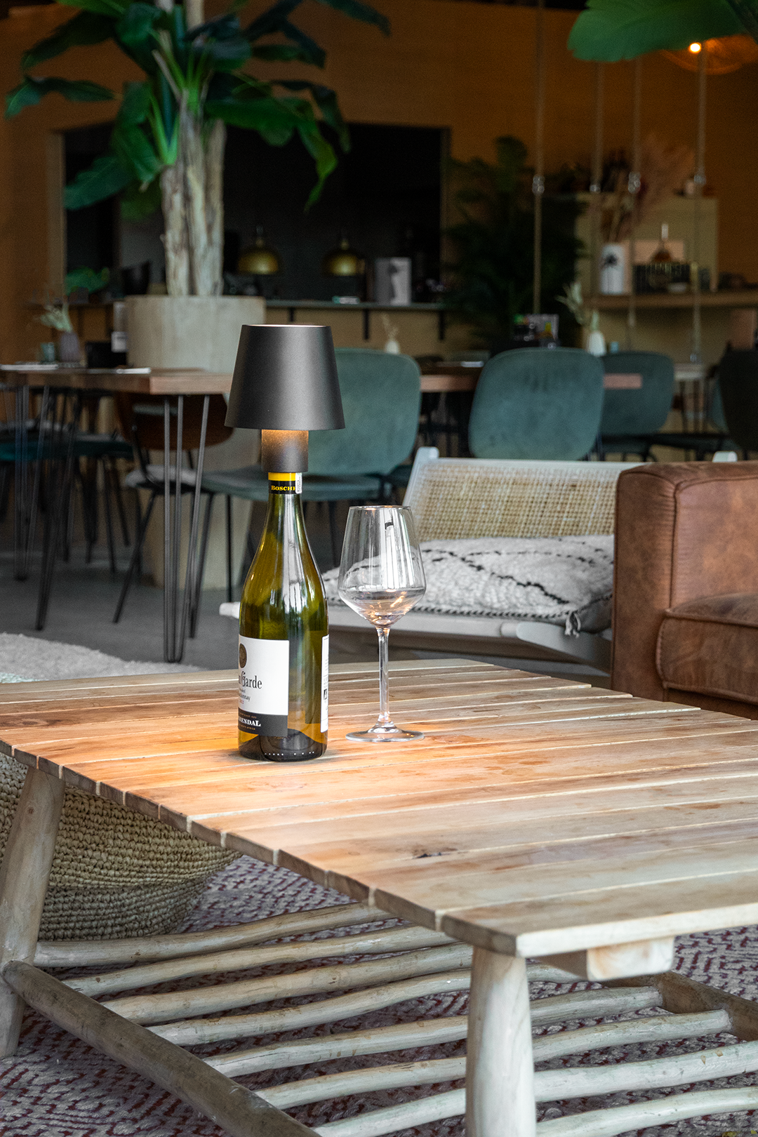 Versailles Rechargeable Bottle Lamp on a Wooden Table Inside a Restaurant Lit Up Next a Wine Glass Versailles Rechargeable Bottle Lamp in Black on a Wooden Table Inside a Restaurant Lit Up Next to a Wine Glass, Table Lighting, Restaurant Lighting, Lighting for Table at Restaurant, Commercial Table Lighting, Hospitality Lighting, Rechargeable Bottle Lamps, LED Lighting, Outdoor Bottle Lamps, Indoor Table Lighting, Cafe Lighting, Bottle Lamps for Cafes